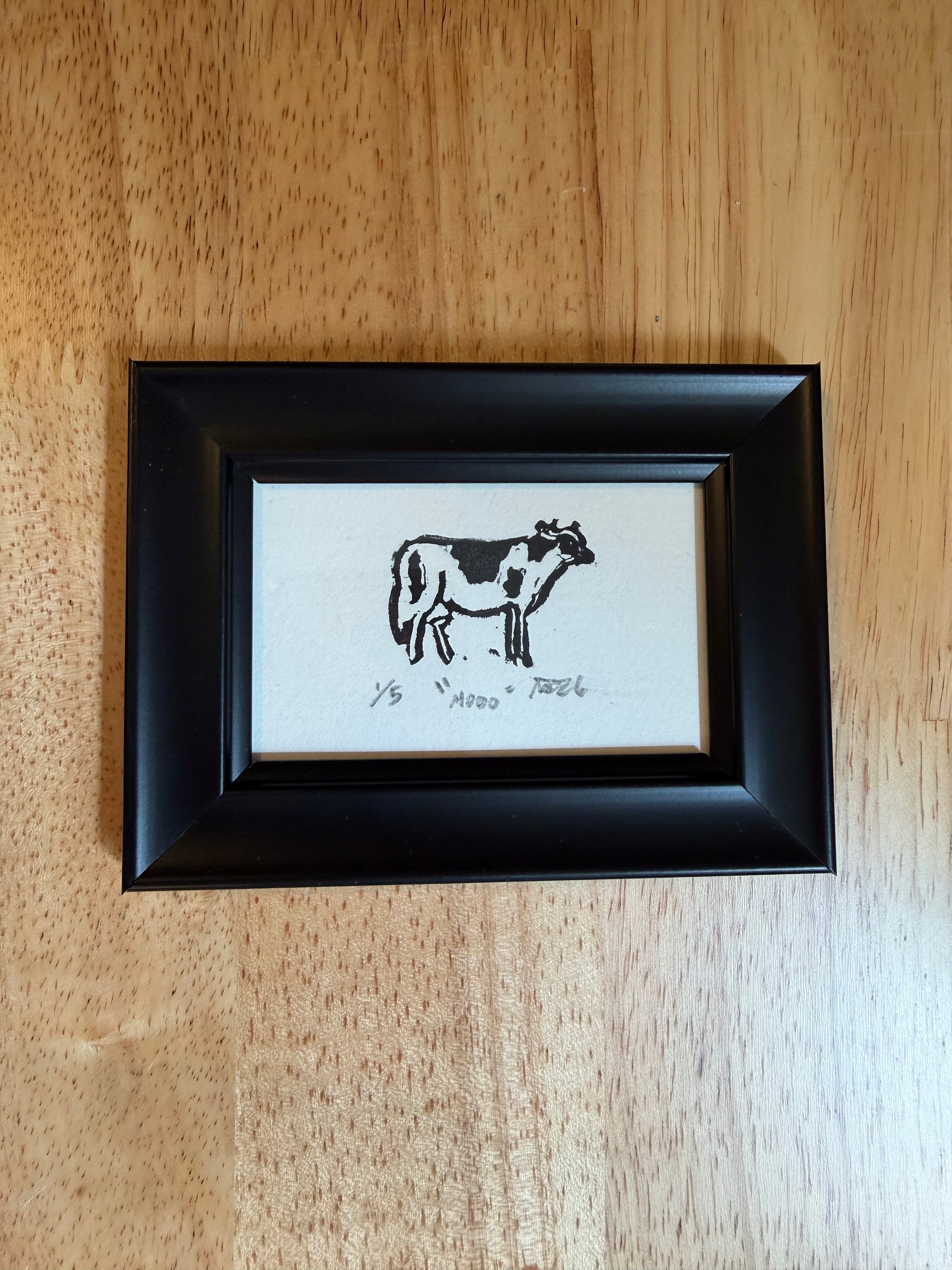 A tiny black and white cow in a black frame, titled "Moooo"